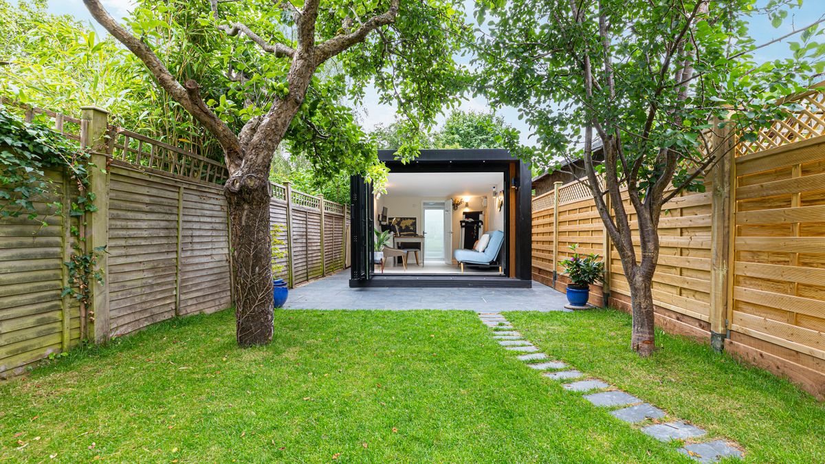 garden with garden office and neat fencing to one side