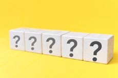 Question mark symbol on wooden blocks with yellow background