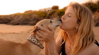 Woman kissing her whippet on nose