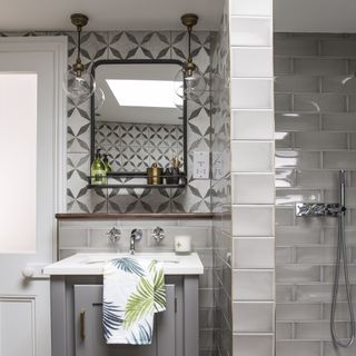 bathroom with grey tiles mirror and basin