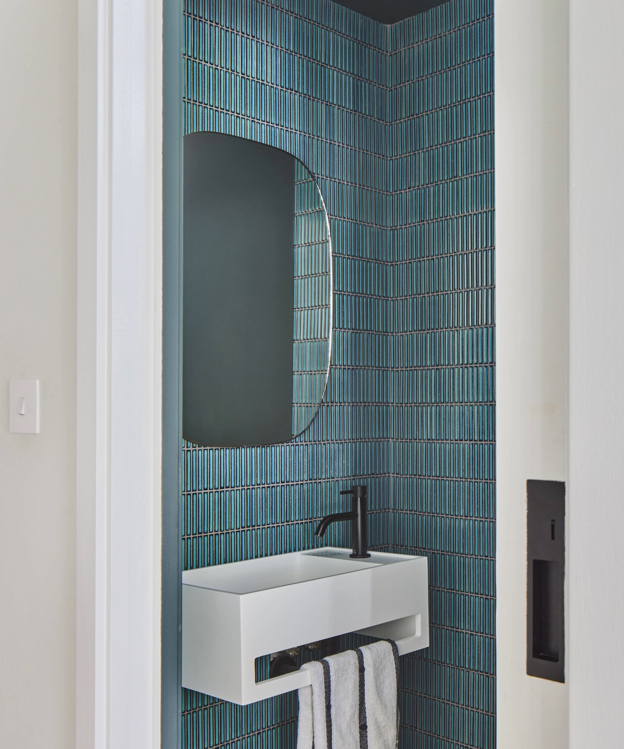 Understairs toilet with blue thin vertical tiles