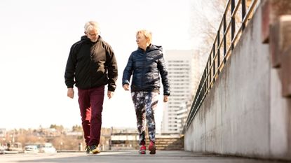 Older couple walking together through a city