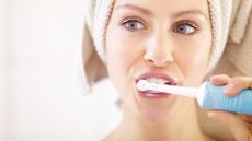 Woman brushing her teeth with an electric toothbrush