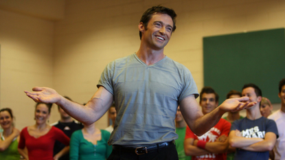 Hugh Jackman holding his arms out speaking to people
