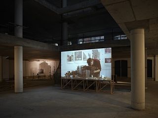Film on screen in dimly lit exhibition space