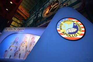 The front façade for the "Ad Astra Per Aspera" exhibit at Kennedy Space Center Visitor Complex in Florida features the crew patch and a towering photo of the Apollo 1 astronauts.