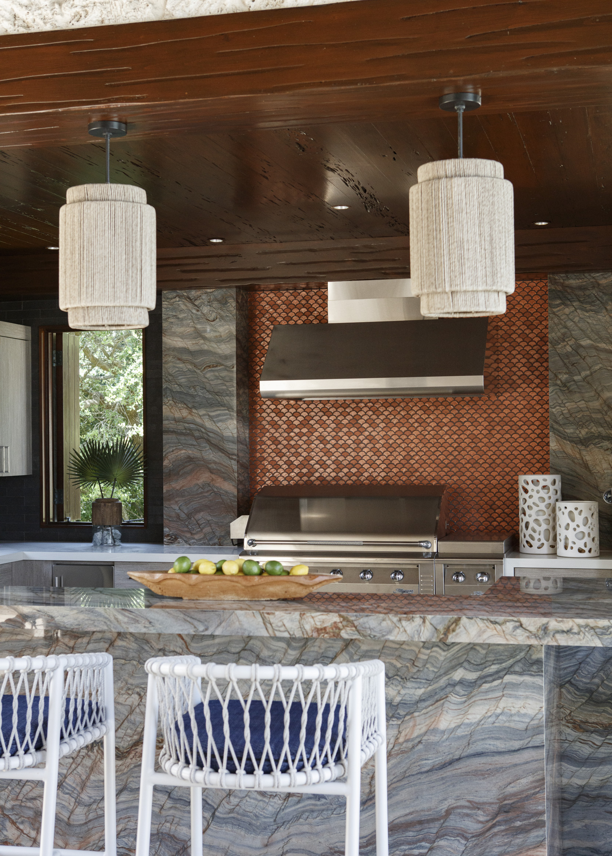 A kitchen with a stone island and a mosaic tiled range backsplash