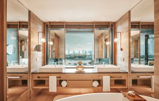 Bathroom with his and hers sinks and mirrors and windows looking out over the city