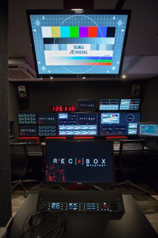 Riedel solutions power a revamped control room shown here with colorful monitors alit.