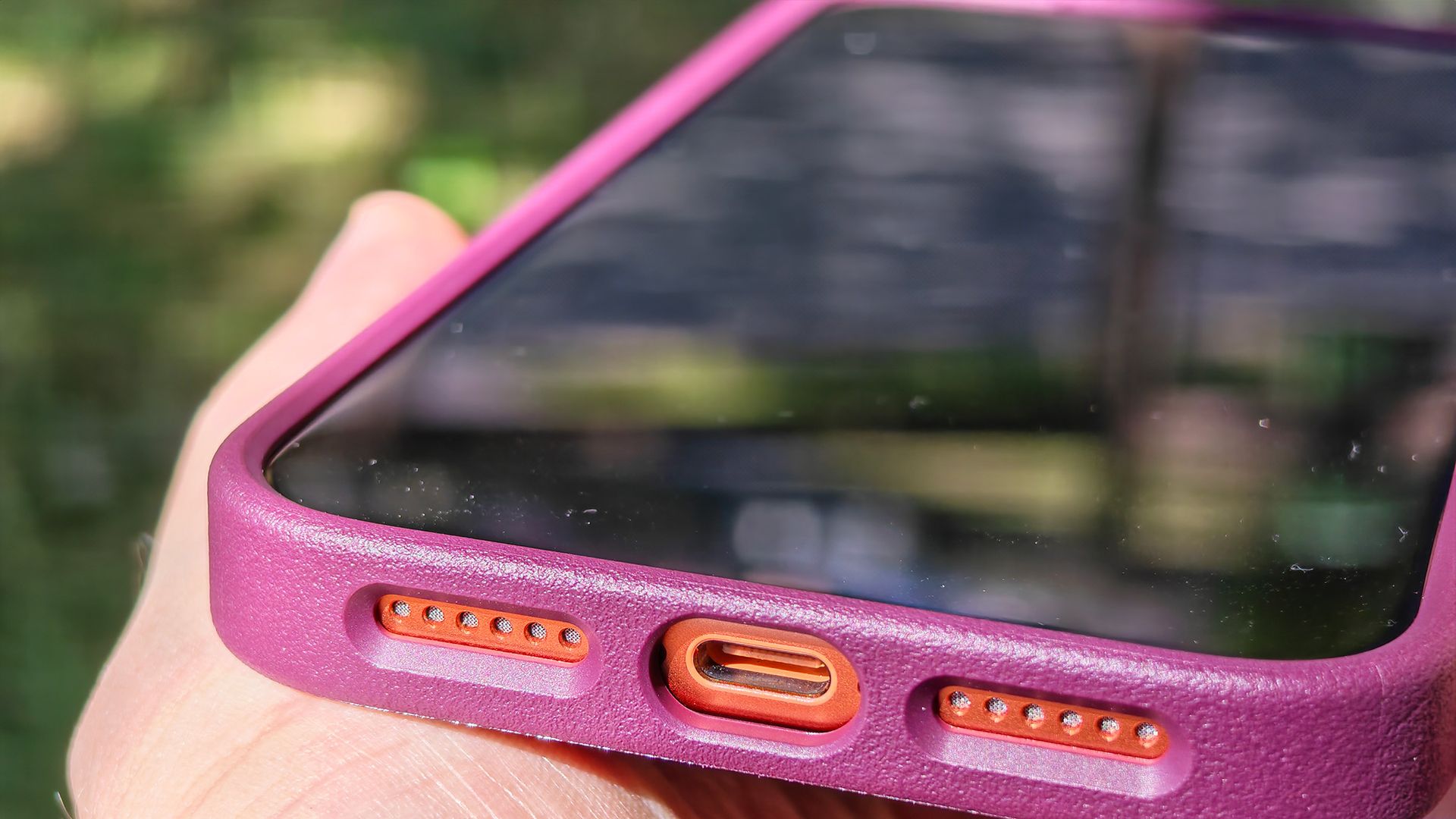 A burgundy Dbrand MNML case on an orange Apple iPhone 17 Pro Max