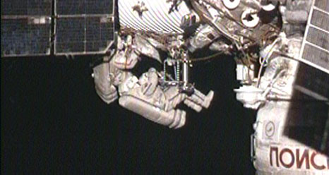 Spacewalker Dmitry Kondratyev installs the Molniya-Gamma experiment on the outside of the Zvezda service module. Oleg Skripochka (slightly out of frame) assists him.