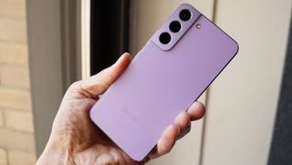 Jemand hält ein Samsung Galaxy S22 in Bora Purple in der Hand