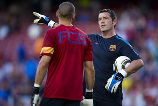 Barcelona goalkeeping coach Carles Busquets gives instructions to Victor Valdes in 2010.