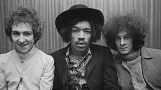 American guitarist and singer Jimi Hendrix (1942-1970) seated in centre with, on left, drummer Mitch Mitchell (1946-2008) and, on right, bassist Noel Redding (1945-2003) of the Jimi Hendrix Experience, in London circa August 1967.