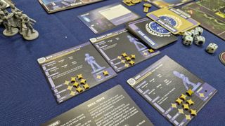 Cards, tokens, and miniatures from Star Trek: Away Missions on a blue surface