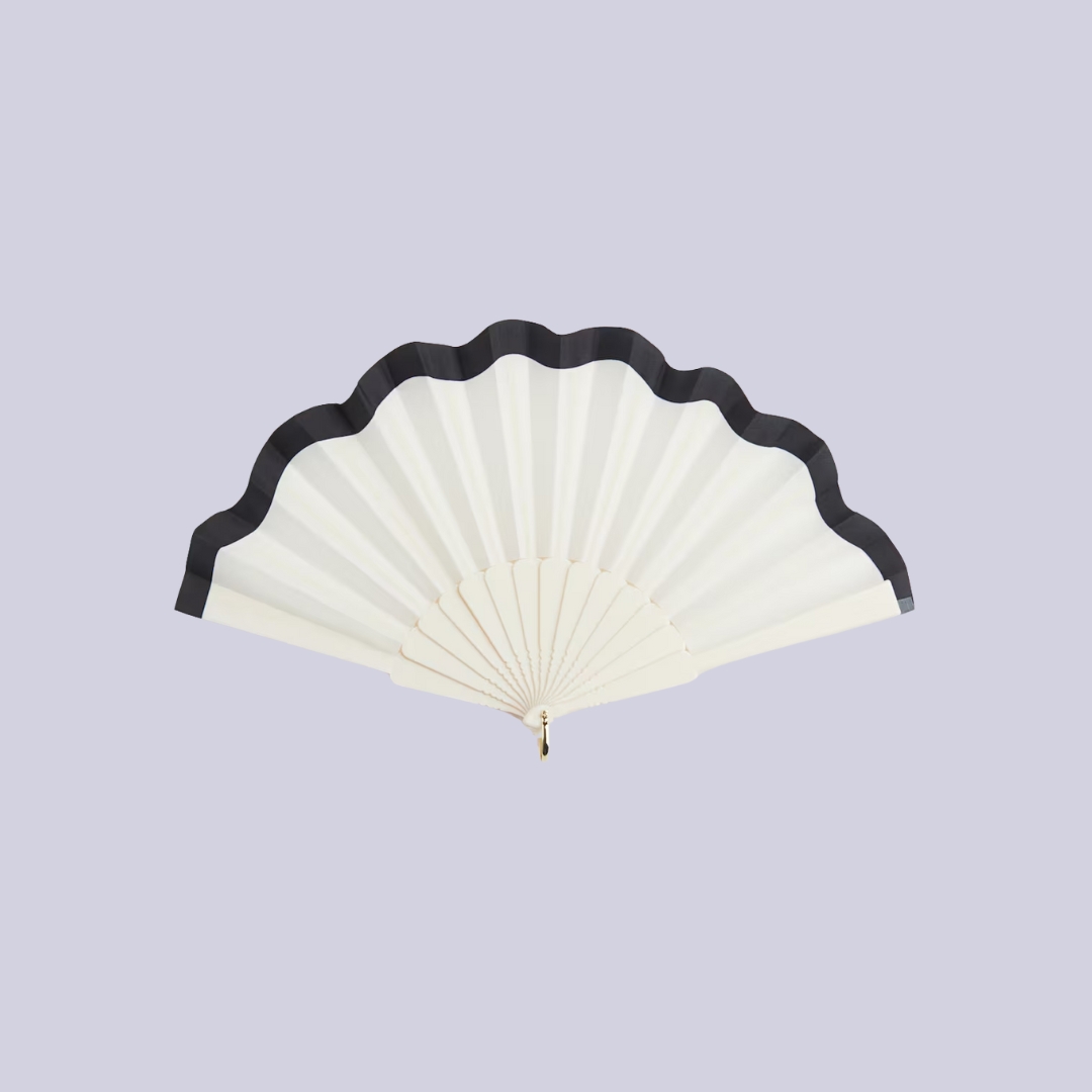 A scalloped-edge fan in white with black rim sits against lilac background.