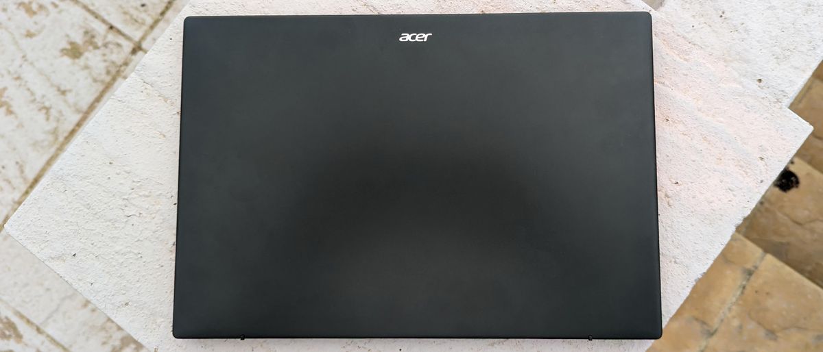 A black Acer Swift Edge 16 laptop sitting on a garden table