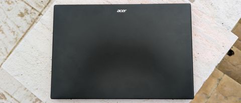 A black Acer Swift Edge 16 laptop sitting on a garden table