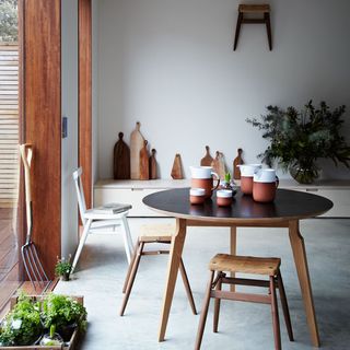 white wall room wooden table with stool and plants