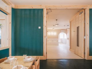 green feature wall among timber interiors