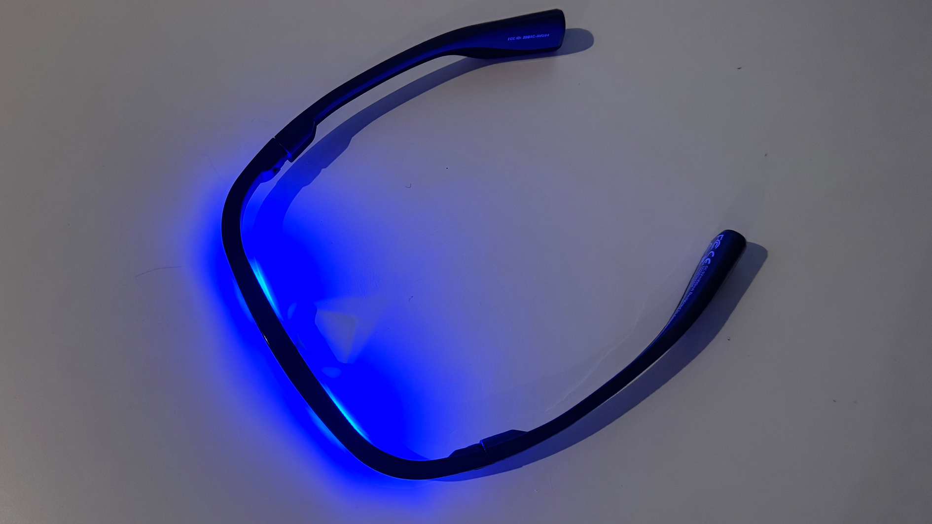 AYO+ Light Therapy Glasses on a grey work surface