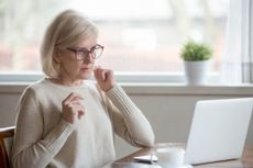 Aged woman using laptop confused seeing error message