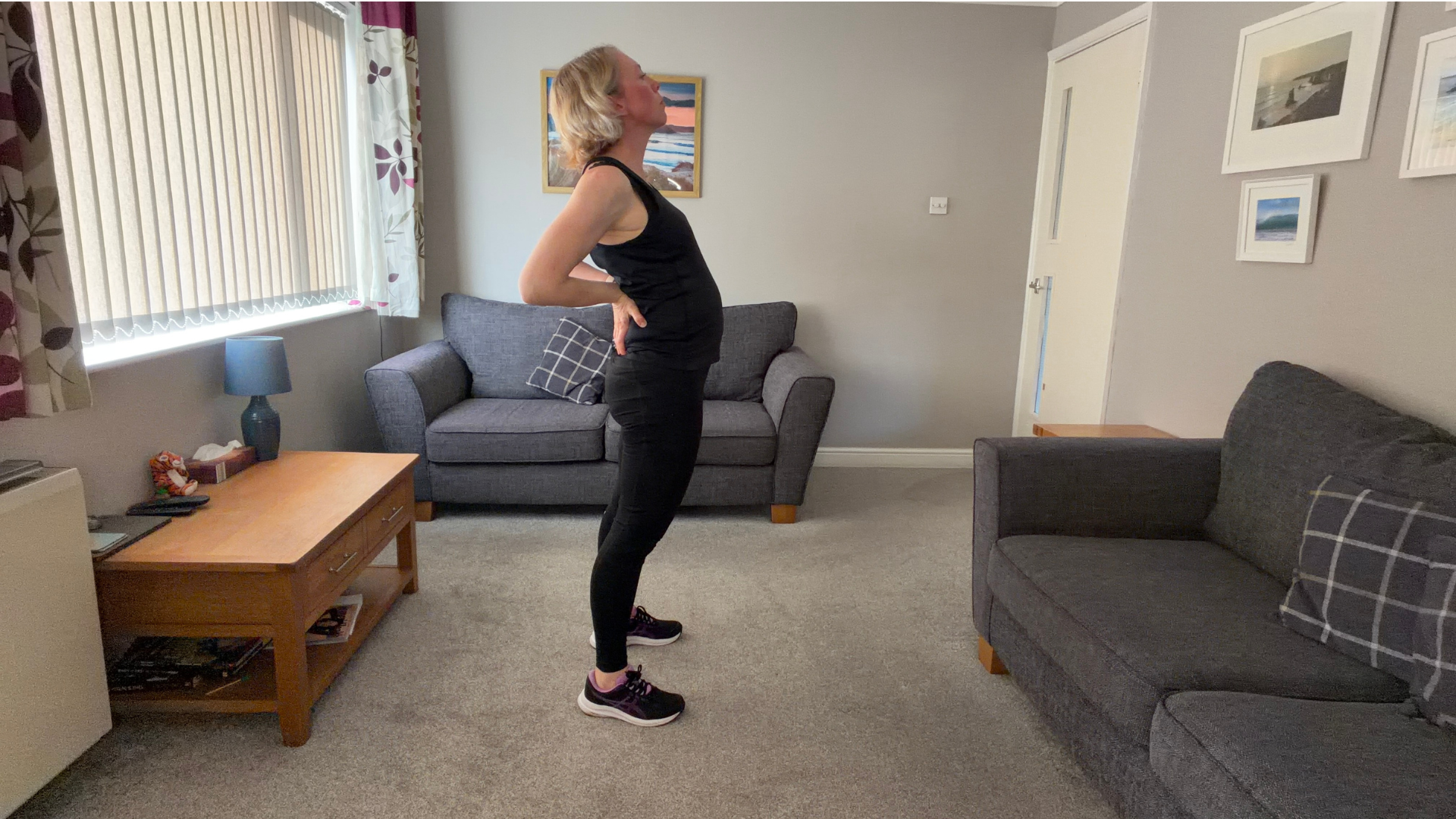 Personal trainer Becky Fuller performing stretching demonstrations in a living room
