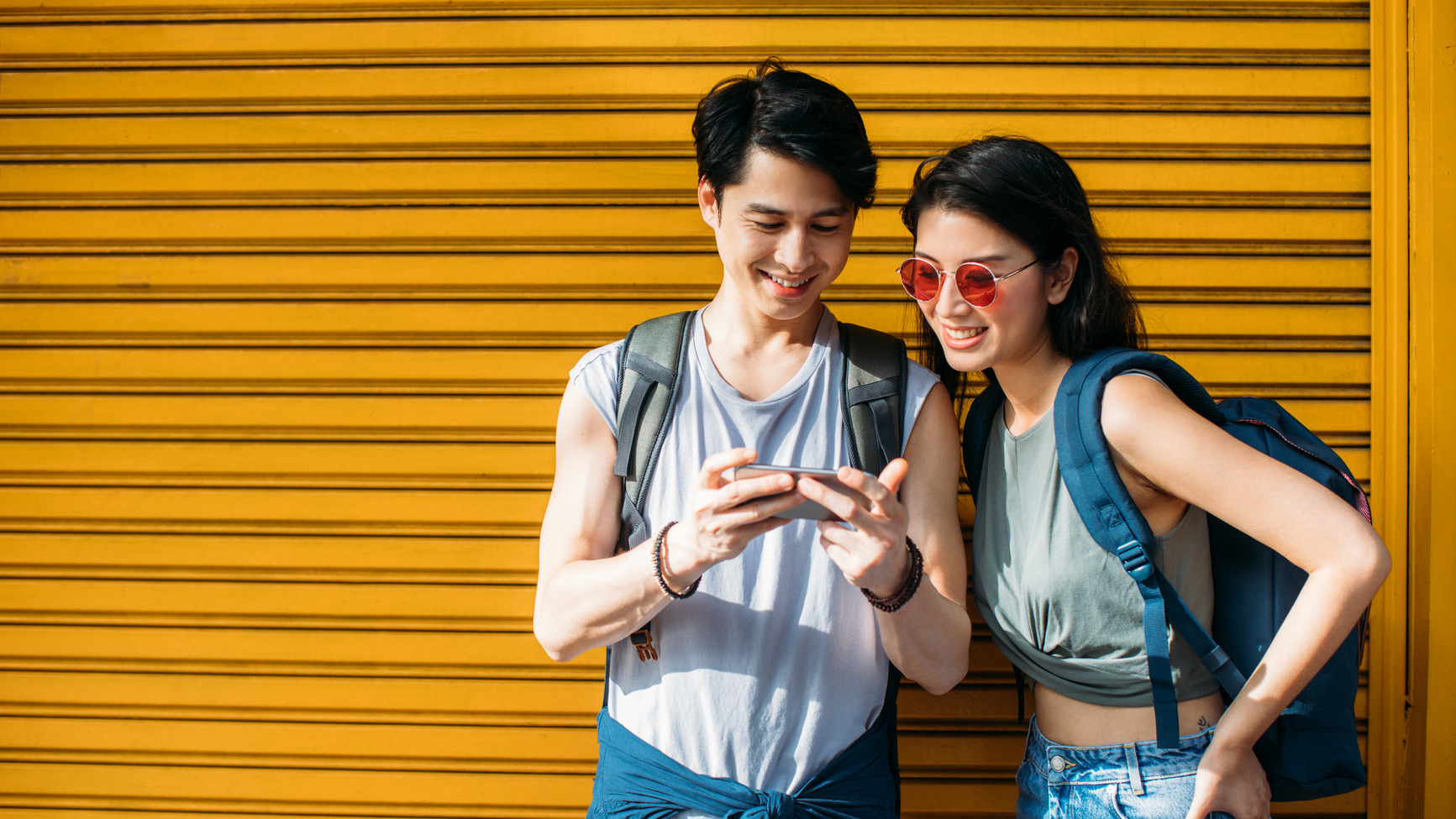 Young couple smiles as they look at their phone