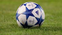 Champions League football lying on grass.
