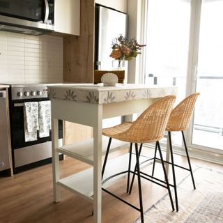Small kitchen island with patterned top and wicker bar stools