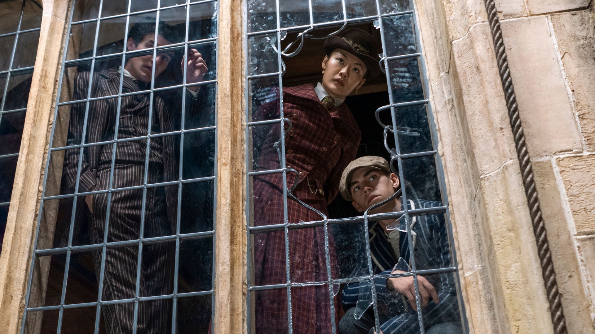 Gulun and Sherlock look through a broken window