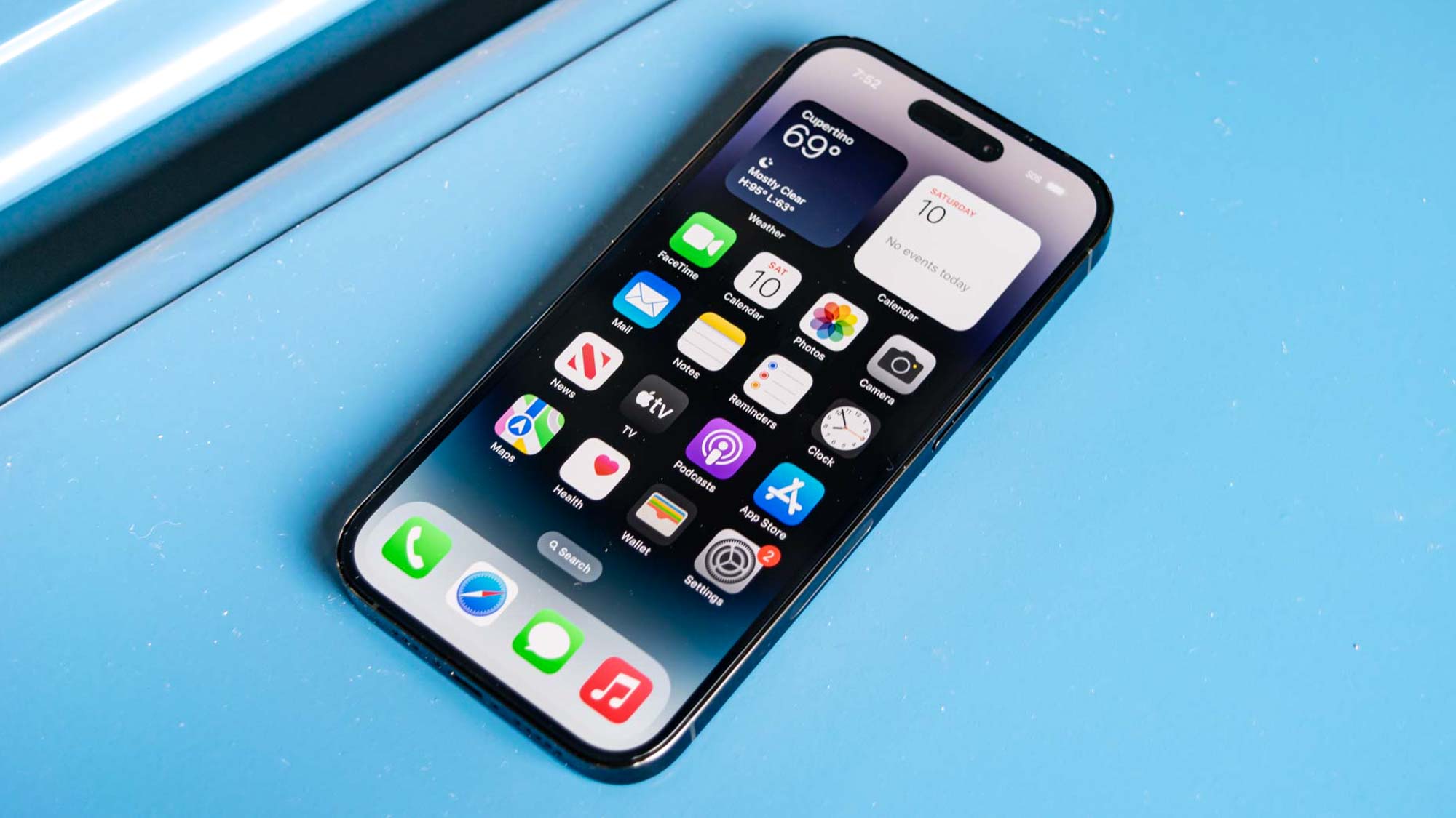 iPhone 14 Pro shown from front displaying iOS16 home screen