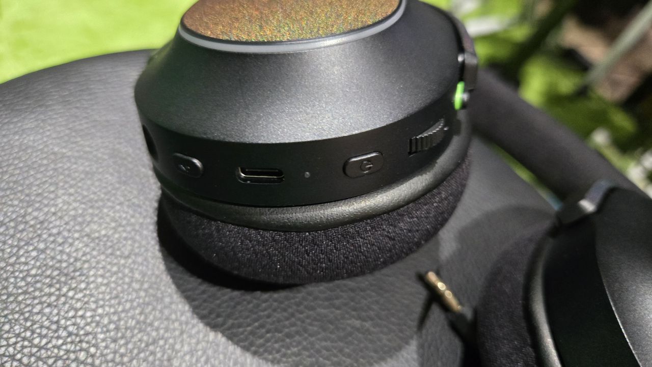 The Razer Barracuda X Chroma wireless gaming headset with a colorful finish on a chair.