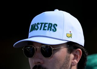 A patron wearing a white Masters cap