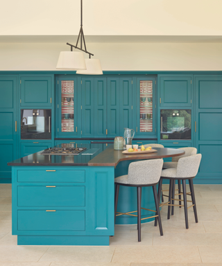 blue kitchen cabinetry and kitchen island with tlal stools