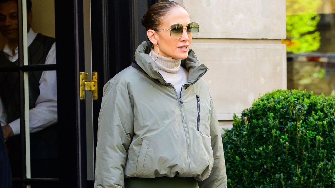 Jennifer Lopez walks in New York City wearing an all green athleisure look including a green windbreaker and green leggings