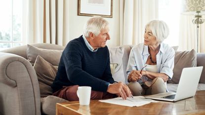 picture of elderly couple working on finances in their living room