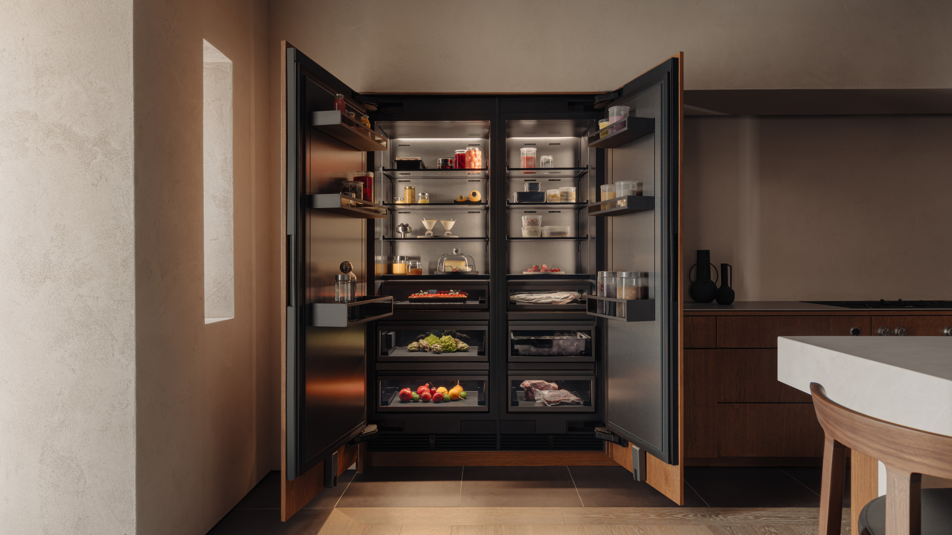 open gaggenau fridge in a wood panelled kitchen with wooden floors
