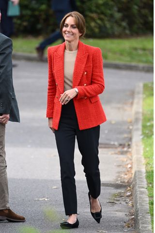 Catherine, Princess of Wales wears a red blazer, black trousers and black pumps as she joins a Portage Session for her 'Shaping Us' campaign on early childhood on September 27, 2023 in Sittingbourne, England. Portage is a service which supports children with disabilities and special educational needs and their families.