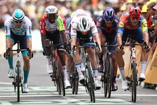 Soudal Quick-Step team's Belgian rider Tim Merlier (C) sprints to the finish line to win ahead of Lidl - Trek team's Italian rider Jonathan Milan (R) placing second and Bahrain - Victorious team's German rider Phil Bauhaus (L) placing third in the 3rd stage of the 112th edition of the Tour de France cycling race, 178.3 km between Valenciennes and Dunkerque (Dunkirk), Northern France, on July 7, 2025. (Photo by Anne-Christine POUJOULAT / AFP) (Photo by ANNE-CHRISTINE POUJOULAT/AFP via Getty Images)