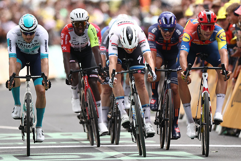 Soudal Quick-Step team&#039;s Belgian rider Tim Merlier (C) sprints to the finish line to win ahead of Lidl - Trek team&#039;s Italian rider Jonathan Milan (R) placing second and Bahrain - Victorious team&#039;s German rider Phil Bauhaus (L) placing third in the 3rd stage of the 112th edition of the Tour de France cycling race, 178.3 km between Valenciennes and Dunkerque (Dunkirk), Northern France, on July 7, 2025. (Photo by Anne-Christine POUJOULAT / AFP) (Photo by ANNE-CHRISTINE POUJOULAT/AFP via Getty Images)