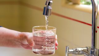 Pouring a glass of water from a kitchen faucet