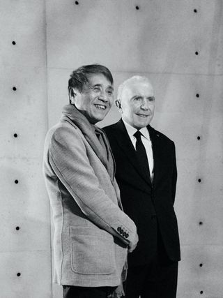 Black & white portrait of Tadao Ando and François Pinault shaking hands.