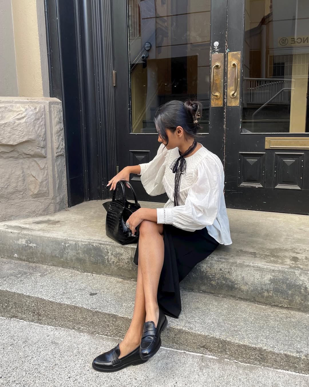 Woman sitting on stairs with a claw clip in her hair.
