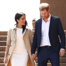 Prince Harry and Meghan Markle look lovingly at each other while descending stairs