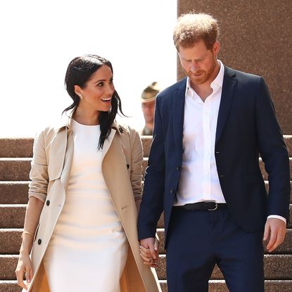 Prince Harry and Meghan Markle look lovingly at each other while descending stairs