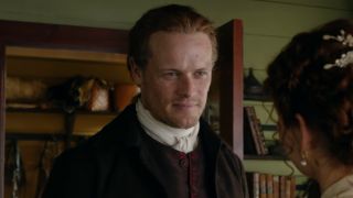 A screen shot of Sam Heughan as Jamie smiling in Season 5 of Outlander.