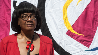 Diane Abbott photographer in front of a banner at an event in 2021