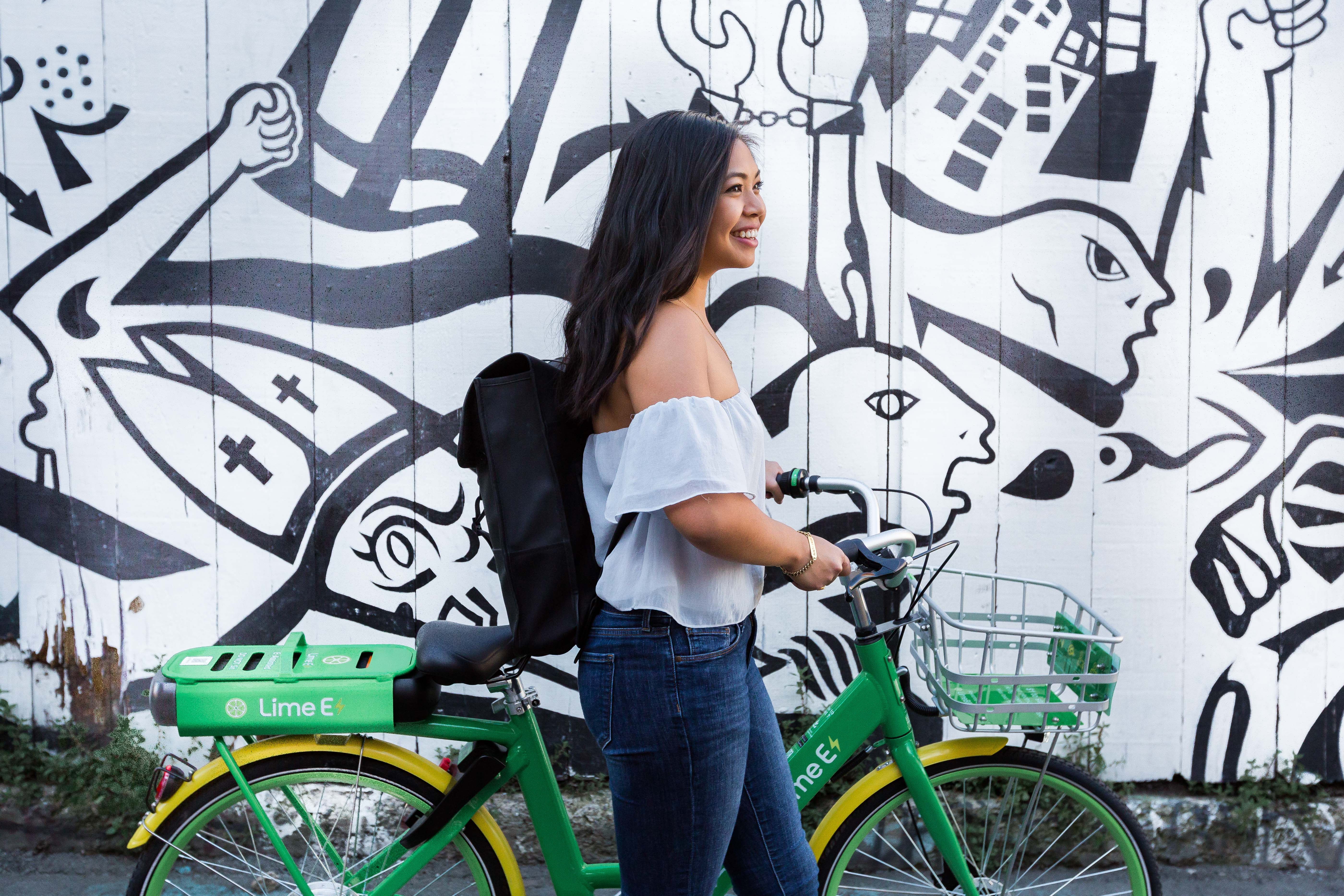 Woman pushing Lime e-bike