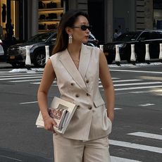 Woman on street wears beige waistcoat and beige trousers